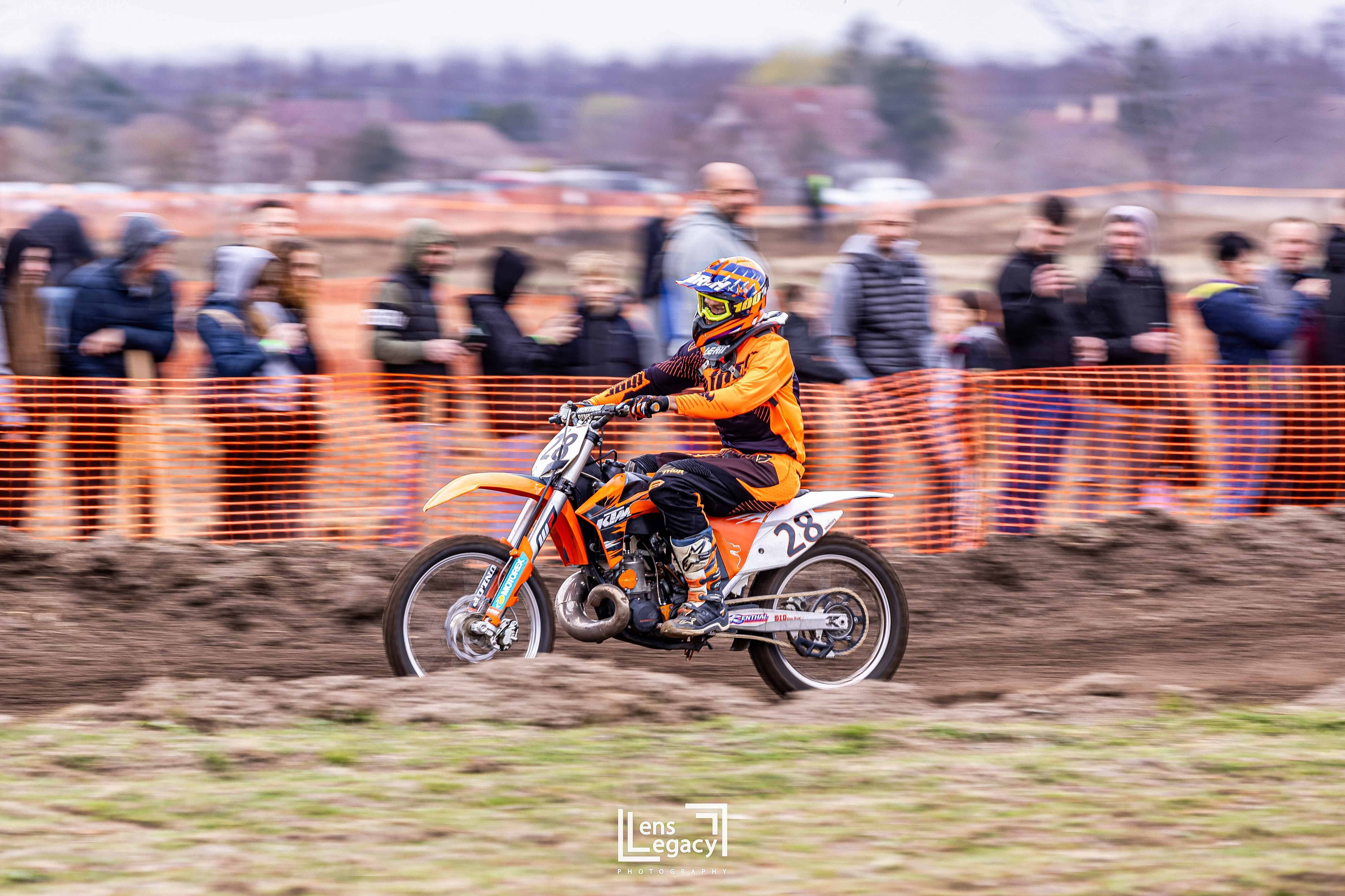 A motocross rider racing past a crowd