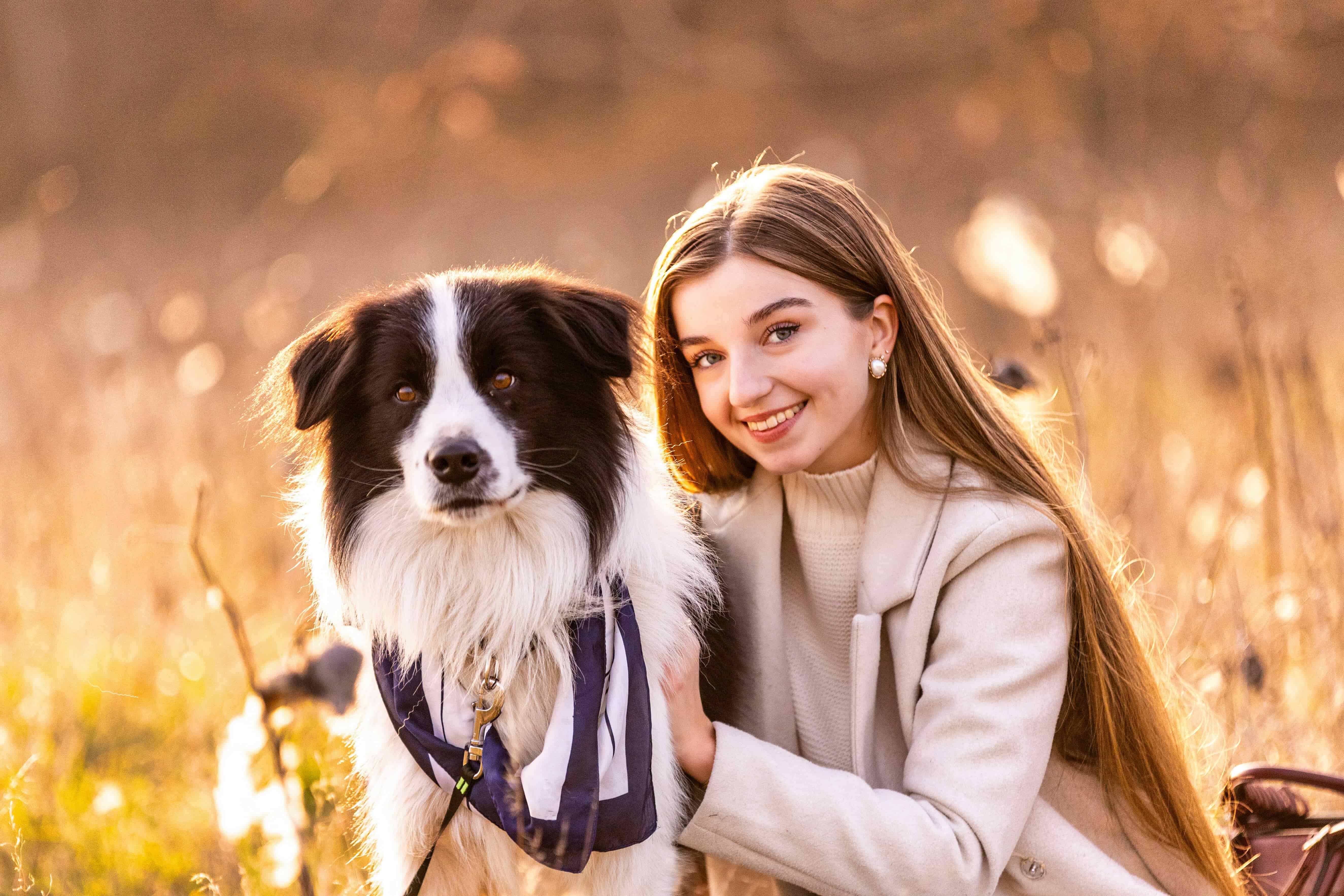 A woman and her dog in the golden light of a field